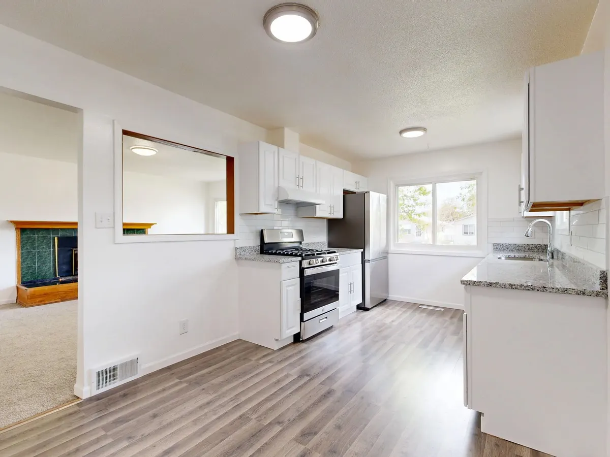 Renovated white kitchen with new cabinets and flooring